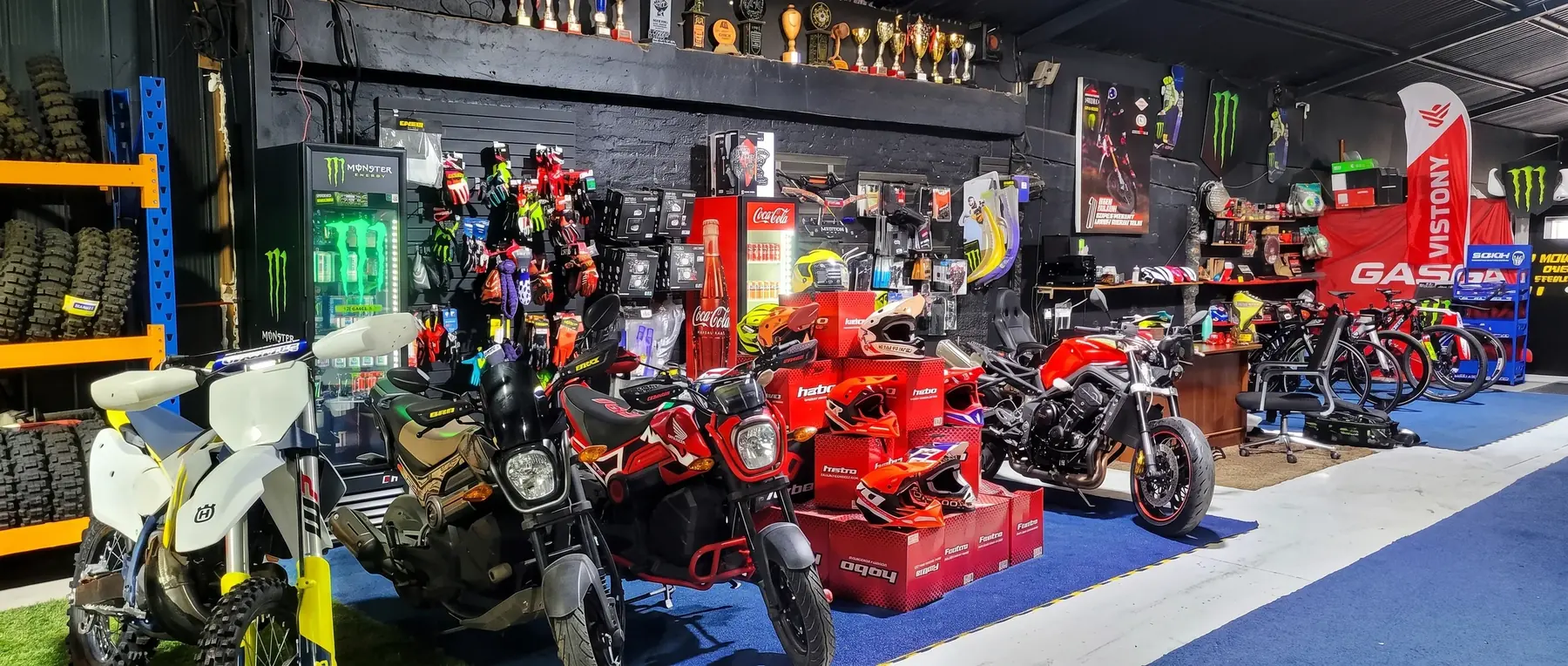 Interior de la tienda: motos alineadas y estanterías de equipamiento.